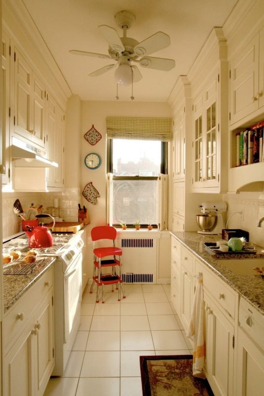 galley kitchen layout in white with crown molding via Apartment Therapy
